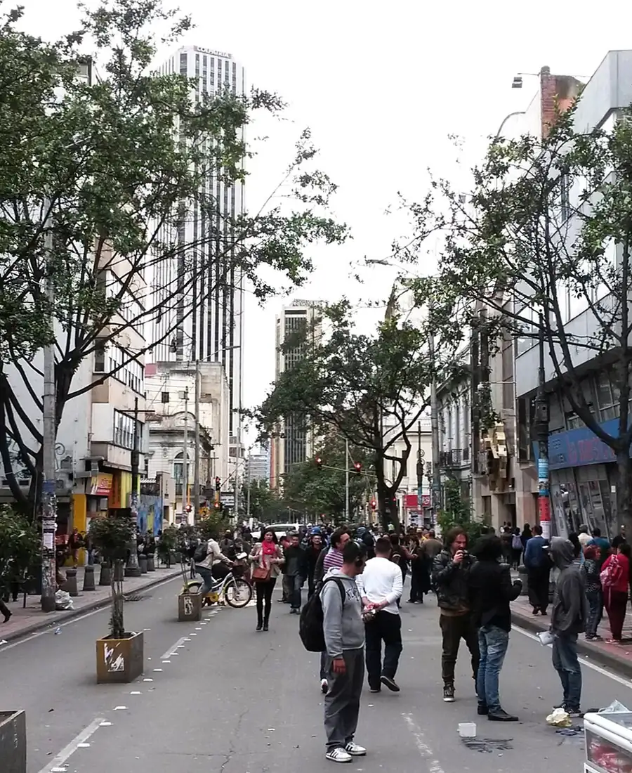 Personas caminando por la Carrera Séptima peatonal de Bogotá, entre árboles y edificios